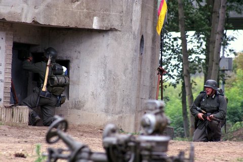 niemiecki żołnierz zakłada ładunek wybuchowy na drzwi do bunkra