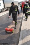 Foto: strażacy rozsypują specjalny proszek wchłaniający olej