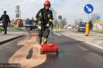 Foto: strażacy rozsypują specjalny proszek wchłaniający olej
