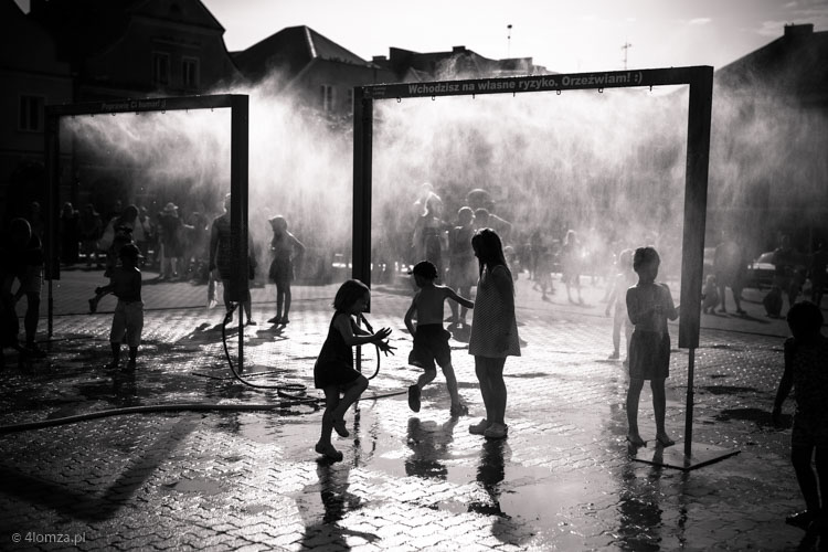 Dzieci bawią się w bramkach wodnych na Starym Rynku w Łomży