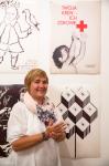 Foto: Córka Jerzego Katarzyna, w tle na plakacie PCK